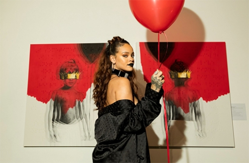 Rihanna posa na frente da capa e da contracapa de seu novo álbum, que tem as informações em braile. Ela usa roupas pretas e segura uma bexiga vermelha.